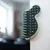 Black and white wall brush with plastic bristles, mounted on a white wall. Suitable for coat care by rubbing.