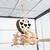 Jouet suspendu en forme de cœur avec motifs cœurs découpés, boules et bâtonnets en bois et corde, accroché dans une cage pour oiseaux ou petits animaux.