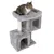 Rascador gris con dos cuevas, una superficie para tumbarse arriba y un poste rascador de sisal. Gato sentado en la superficie superior.