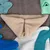 Beige fleece fabric in triangular shape, surrounded by colourful fabric pieces in blue, white and green on grey background.