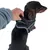 Hundegeschirr mit Griff, schwarz mit reflektierenden Streifen, wird von einer Hand gehalten. Geeignet für Kontrolle und Sicherheit beim Spaziergang.