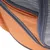 Detalhe de bolsa ou mochila em tecido laranja com fecho cinzento e rede cinzenta visível.
