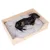 Holz-Hundebett mit grauem, gepolstertem Kissen. Ein kleiner Hund liegt entspannt darin.