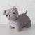 Peluche grigio a forma di cane con occhi neri e orecchie corte, su sfondo bianco.