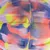 Nahaufnahme eines bunten Spielballs mit Textur in Neonfarben: Gelb, Blau, Pink und Lila.