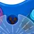 Jeu d’intelligence pour animaux en plastique bleu, violet et transparent, compartiments contenant des croquettes brunes visibles.