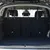 Grille de séparation en métal installée entre le coffre et les sièges arrière d’une voiture, vue depuis l’ouverture du coffre.