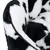 Close-up of a black and white patterned, soft fabric material with plush texture and black edge.