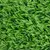 Close-up of artificial green grass carpet with detailed structure of plastic fibres.