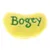 Juguete de peluche amarillo con inscripción verde 'Bogey'.
