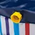 Close-up of a yellow drain valve on a blue and striped pool made of plastic.