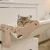 Wooden cat hammock mounted on a chest of drawers with a cat lying on it. Visible: wooden frame and fabric lying surface.