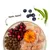 Schale mit rohem Hühnerfleisch, Trockenfutter, Cranberrys, einer orangefarbenen Blüte, daneben Blaubeeren und Erbsenschote. Text: nom nom! Schale mit rohem Hühnerfleisch, Trockenfutter, Cranberrys, einer orangefarbenen Blüte, daneben Blaubeeren und Erbsenschote. Text: nom nom!