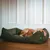 Dog lying asleep in a green, ribbed dog bed with a small label on the side. Dog lying asleep in a green, ribbed dog bed with a small label on the side.