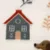 Primo piano di un tessuto con motivo di casa, rami e muso di cane in tonalità di marrone e grigio. Primo piano di un tessuto con motivo di casa, rami e muso di cane in tonalità di marrone e grigio.
