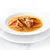 Primer plano de un cuenco con sopa, compuesta por trozos de carne y tiras de verduras en caldo claro.