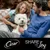 Cane bianco seduto tra due persone, in basso testo: Cesar SHARE THE JOY. Marchio Cesar visibile.