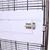Close-up of a white metal door latch on a cage with black wire mesh walls.
