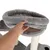 Hand showing the soft, padded surface of a grey cat tree resting area with plush cover and stable construction.