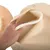 Hand showing the inside of a beige, padded pet bed with soft foam filling.