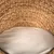 Woven basket made of natural materials with beige cushion, suitable as a lying surface.