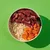 Bowl containing raw meat strips, cooked rice and sliced carrots, showing main ingredients of the product.