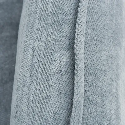 Dettaglio tessuto grigio con motivo a spina di pesce, materiale visibilmente in tessuto.