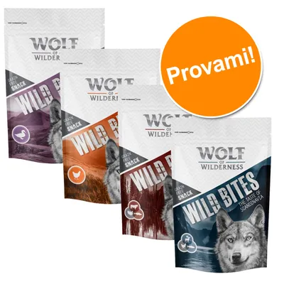 Quattro confezioni di snack Wolf of Wilderness Wild Bites, vari gusti, con scritta 'Provami!' su cerchio arancione. Testo visibile: 'Grain Free Snack', 'The Taste of Scandinavia'.