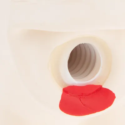 Nærbillede af hvid plastbeholder med åbning og rød forsegling synlig omkring gevindet. Ingen mærker eller tekst synlige.