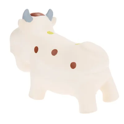Hvidt legetøj formet som ko med brune prikker, blå horn og gule pletter. Lavet af blødt materiale, ingen synlig tekst eller mærke.