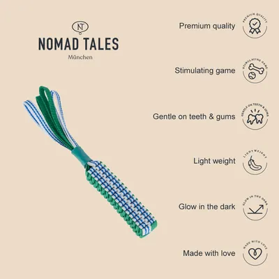 NOMAD TALES München. Texto en inglés: Premium quality, Stimulating game, Gentle on teeth & gums, Light weight, Glow in the dark, Made with love. Juguete de cuerda verde y azul.