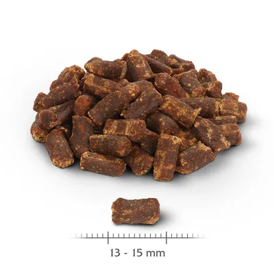 Braune Snackstücke mit einer Grösse von 13-15 mm, dargestellt neben einem Massstab zur Grössenangabe.