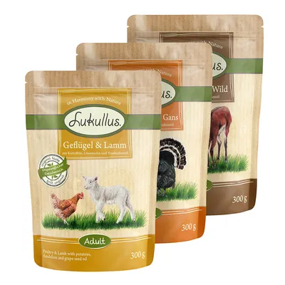 Tri pakiranja Lukullus hrane za pse, vidljive varijante: Geflügel & Lamm 300 g, Gans 300 g i Wild 300 g. Tekst na njemačkom jeziku.