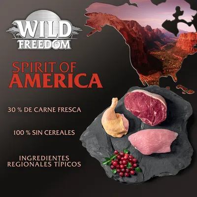 Wild Freedom Spirit of America: 30 % de carne fresca, 100 % sin cereales, ingredientes regionales típicos. Imagen de carne cruda, ave y frutos rojos sobre pizarra.