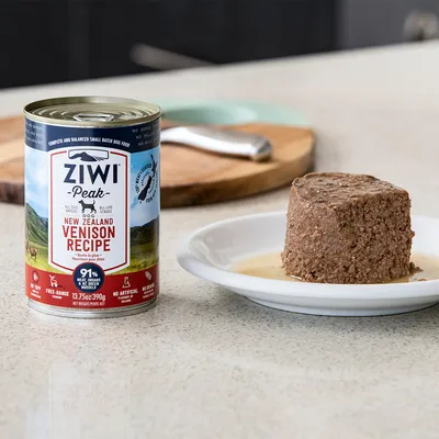 Boîte de pâtée pour chien Ziwi Peak New Zealand Venison Recipe 390 g, texte visible : 91 % viande, abats et moules, sans céréales, sans additifs artificiels, pâtée servie dans une assiette.