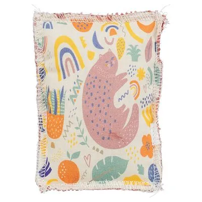 Kussen van stof met kleurrijke print, waaronder een getekende kat, regenbogen, planten en vruchten. Randen zijn rafelig zichtbaar.