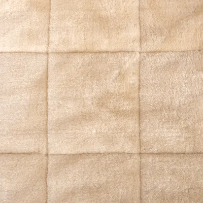 Beige, quadratisch gestepptes Material mit weicher, flauschiger Oberfläche. Geeignet für Heimtierbedarf oder Polsterung.