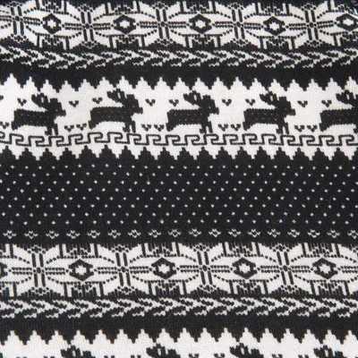 Close-up of black and white knitted fabric with geometric patterns and rows of reindeer motifs, showing the material’s design detail.
