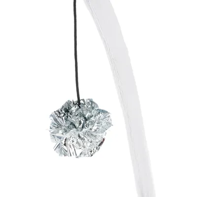 Pompon argenté en film plastique suspendu à une ficelle noire, accroché à une tige recouverte de tissu blanc. Aucun texte ou marque visible.