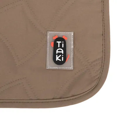 Tiaki logo on brown fabric with quilted pattern.
