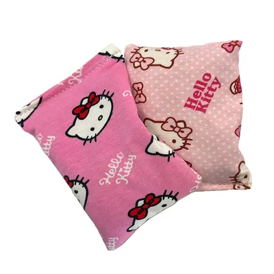 Zwei rosa Kissen mit Hello Kitty-Motiv und Schriftzug, eines mit Punkten und das andere mit wiederholtem Katzenkopf-Design.