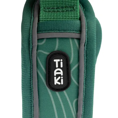 Tiaki-logotyp på grön textil med grå accenter, del av en produkt i slitstarkt material.
