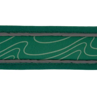 Grönt halsband med grå sömmar och böjt mönster på tyg.