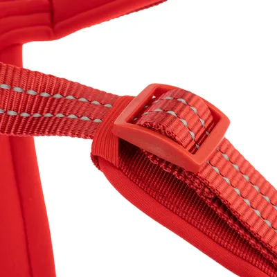 Nærbillede af et rødt bælte med reflekterende striber og plastspænde. Detaljevisning af materiale og forarbejdning.