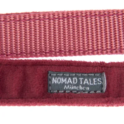 Nomad Tales München. Detailweergave van rood textielmateriaal met label.