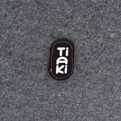 Tiaki. Logo marki na szarym filcu.