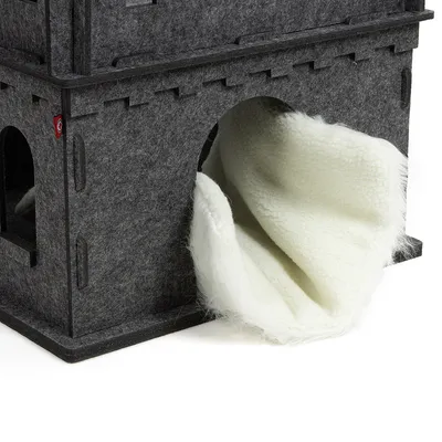 Casa de fieltro gris con forro interior blanco y suave visible a través de una entrada arqueada.