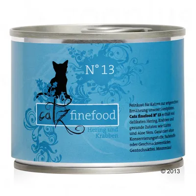 Conservă cu etichetă albastră, text vizibil: N° 13, catz finefood, Hering und Krabben. Text suplimentar în germană despre ingrediente și garanții. Siluetă de pisică pe etichetă.
