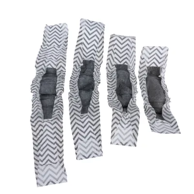 Four grey disposable nappies with zigzag pattern in various sizes, elastic cuffs and visible absorbent inner layer.