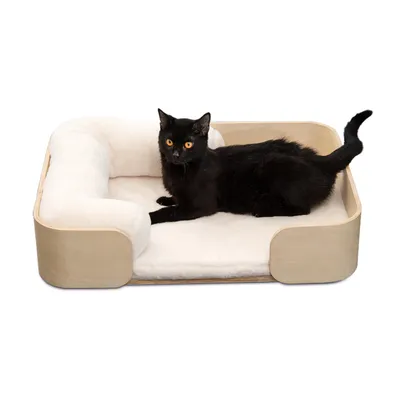 Schwarze Katze liegt in einem rechteckigen Holz-Haustierbett mit weicher, weisser Polsterung.